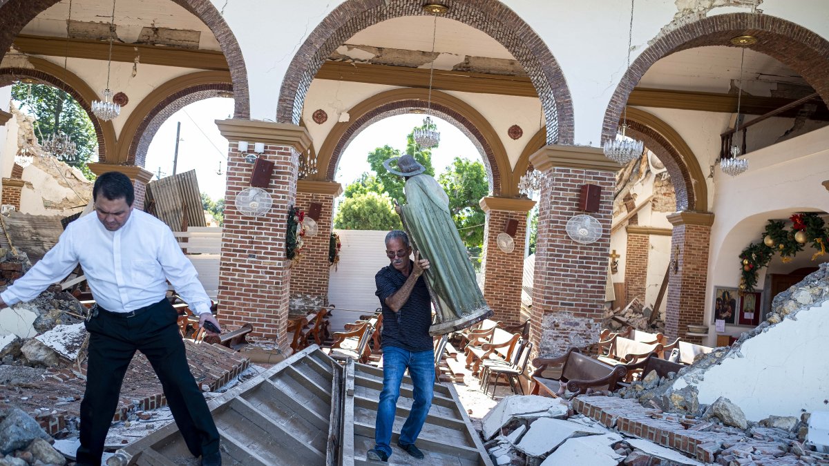 Un hombre lleva una estatua de San Judas de las ruinas de la iglesia Inmaculada Concepción, construida en 1841 y derrumbada después del terremoto.