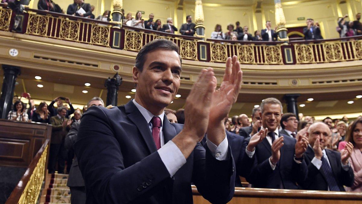 El socialista Pedro Sánchez aplaude después de ganar una votación parlamentaria en España.
