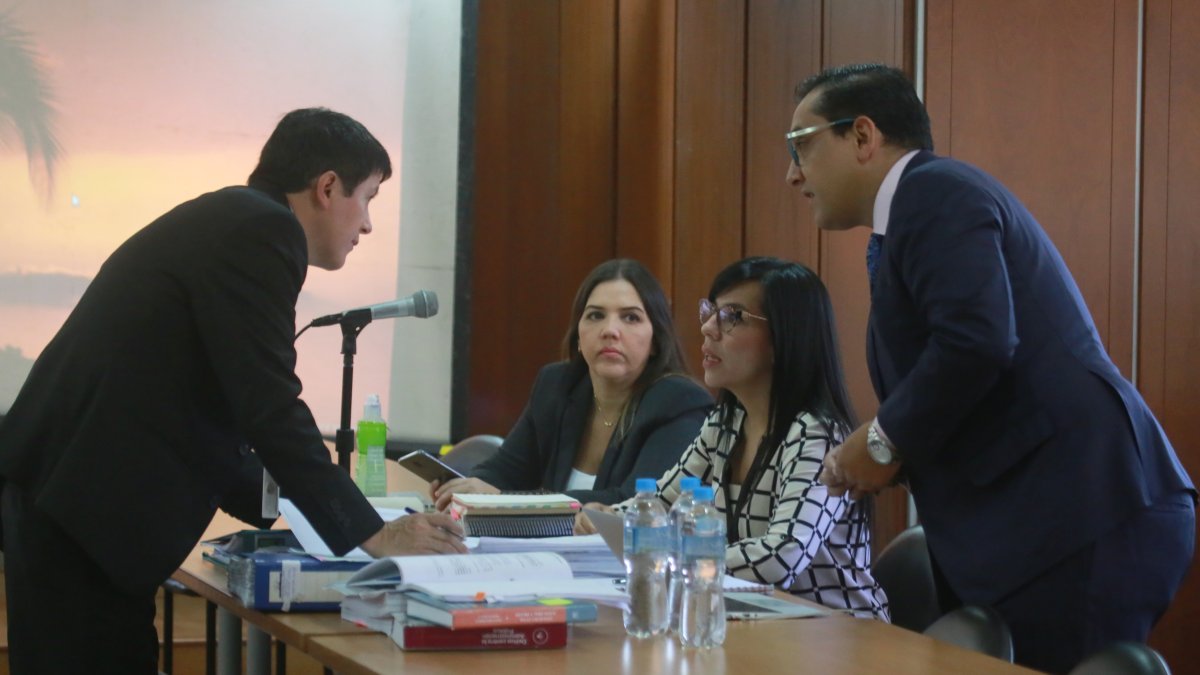 La investigada (centro) junto a su abogada en medio de la sala de audiencia.