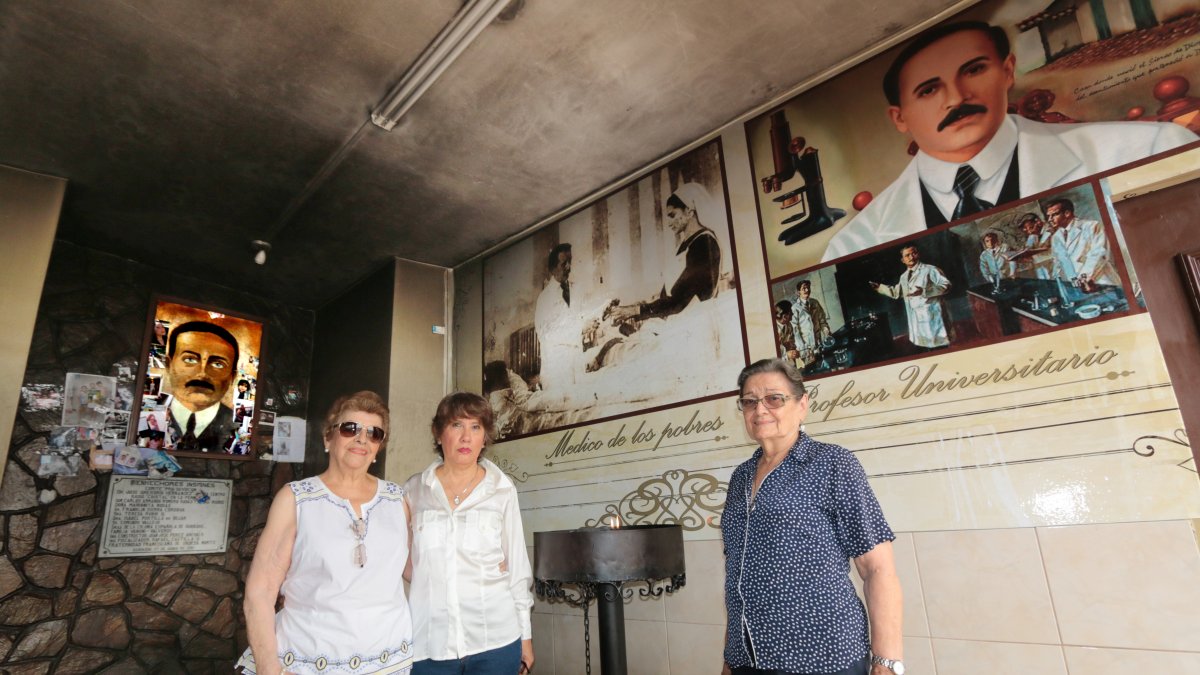 Martha Béjar, presidenta de la Agrupación Cívica Social y Cultural de Urdesa, junto a dos devotas del hermano Gregorio.