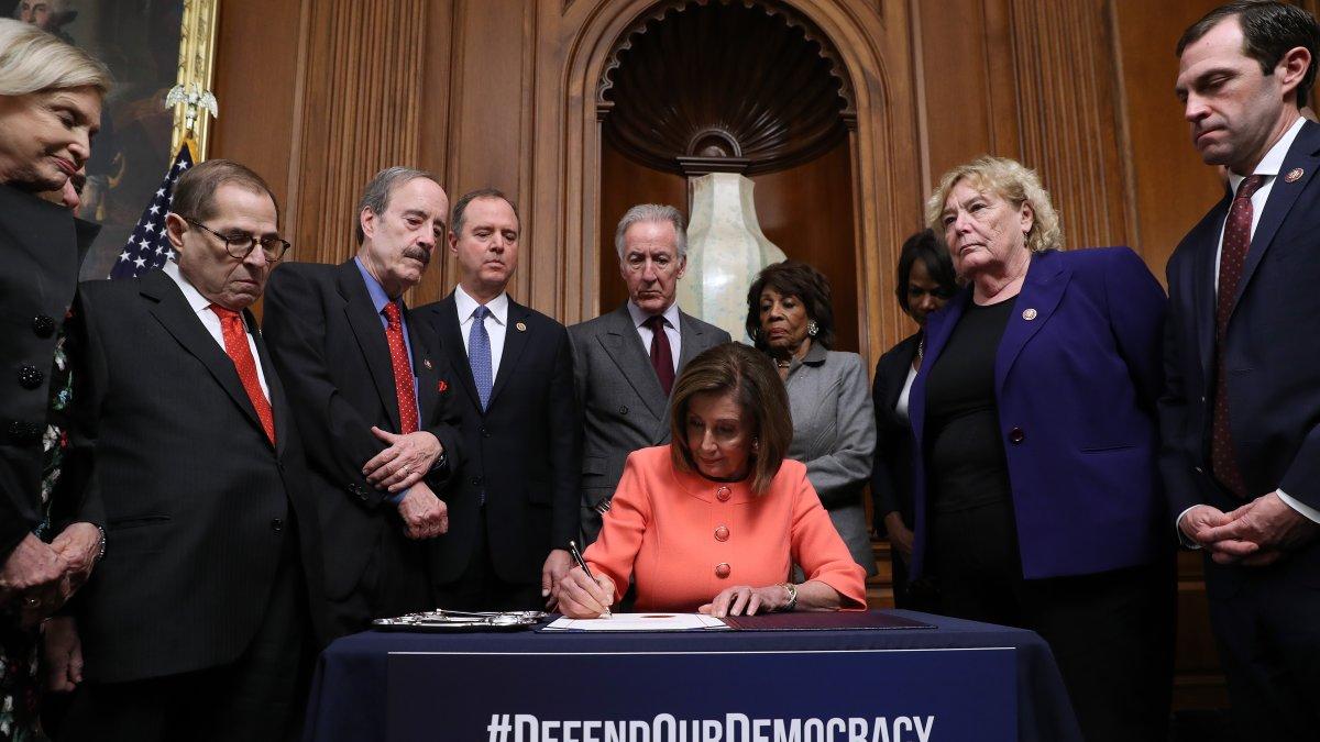 La presidenta de la Cámara de Representantes de los Estados Unidos, Nancy Pelosi,  firma los artículos de juicio político contra el presidente Donald Trump.