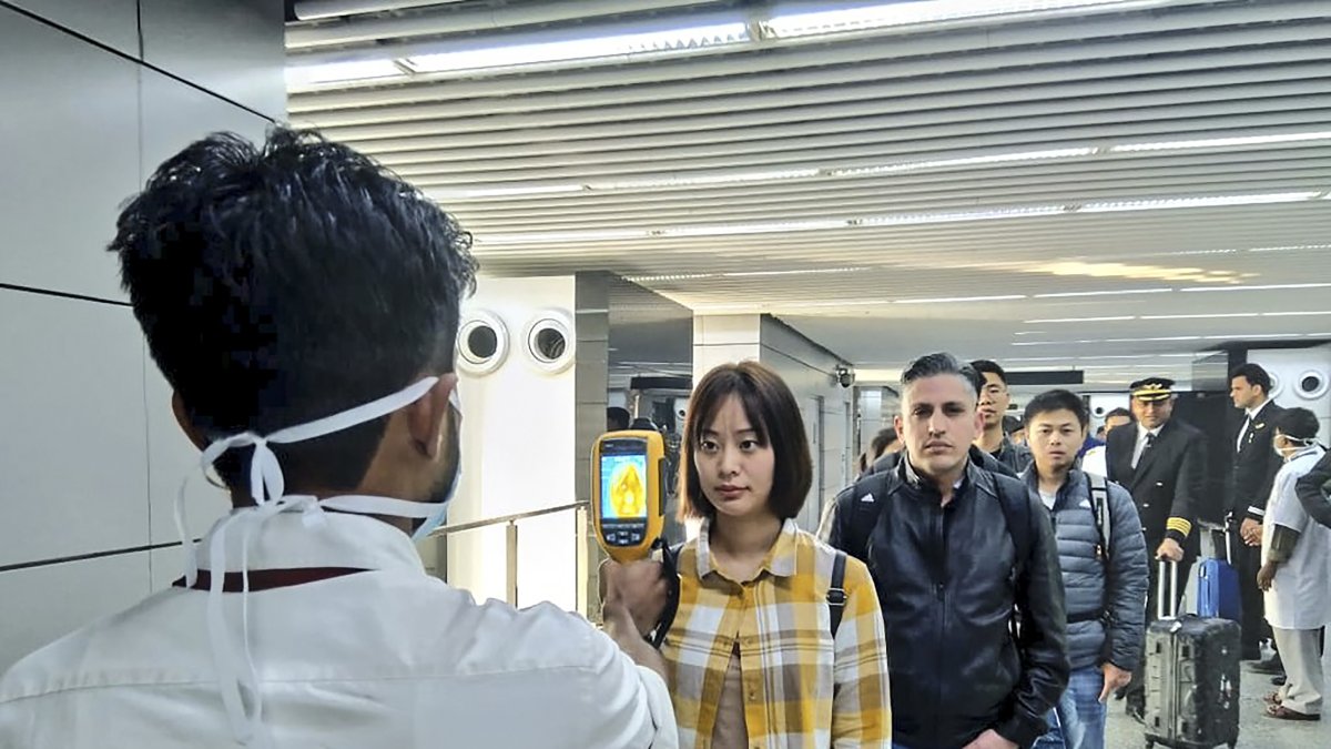 Un hombre usa una cámara termográfica para vigilar el ingreso de las personas al Aeropuerto Internacional Netaji Subhash Chandra Bose en Kolkata, siguiendo las recomendaciones del Ministerio de salud.