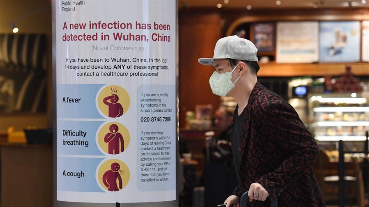 Un hombre con máscarilla arrastra sus maletas por el aeropuerto Heathrow, este viernes, en Londres (Reino Unido).