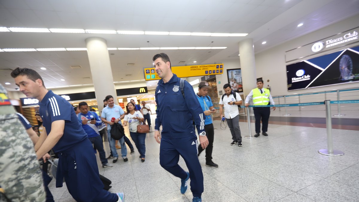 Los jugadores y el técnico Rescalvo (d) compartieron con los hinchas que fueron a recibirlos al aeropuerto.