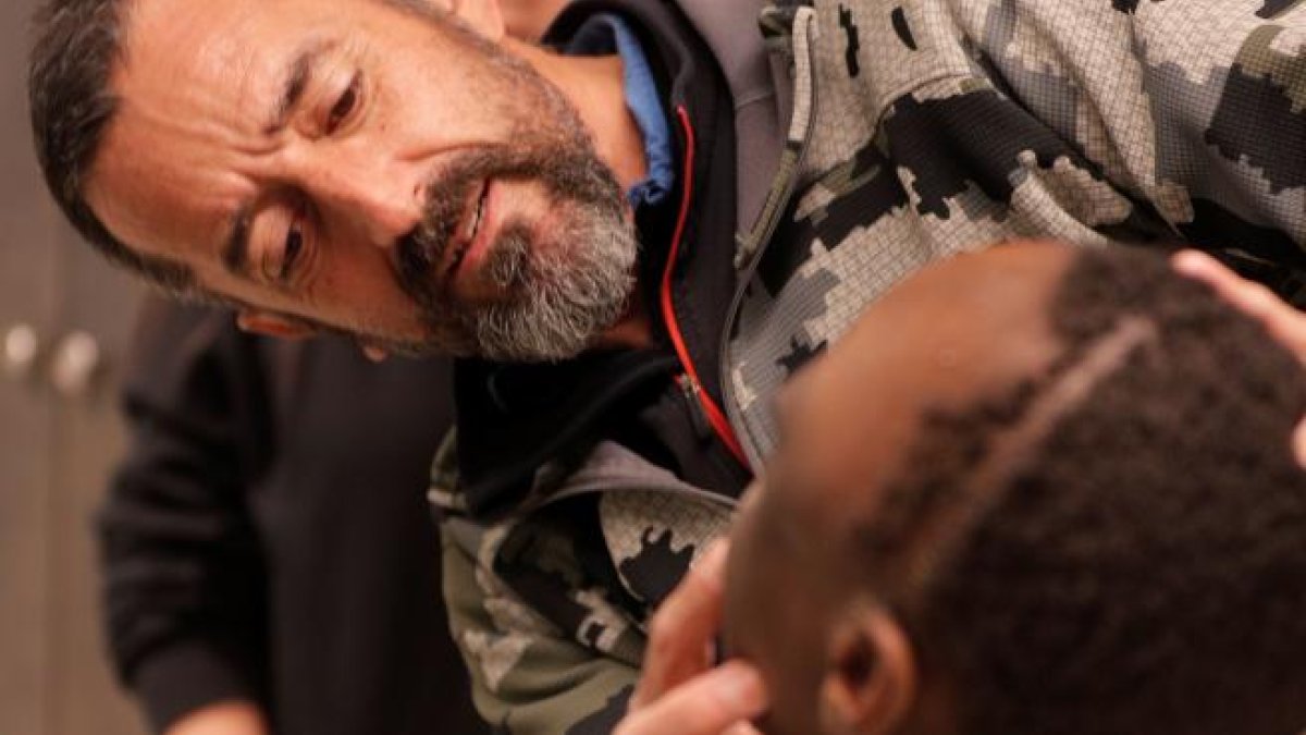 El cirujano Pedro Cavadas observa la cara de Emmanuelle, el niño congoleño de 10 años al que ha extirpado un tumor cráneo facial no maligno.