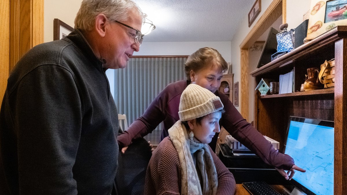 Dan Maccoux, su esposa Cathy y su hija Olivia miran la computadora el pasado 16 de enero.