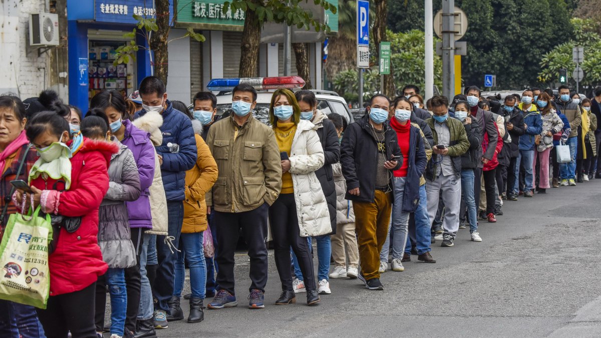 NANNING. Habitantes de esta ciudad china, hace fila al pie de una farmacia, en busca de mascarillas que ha vuelto un producto escaso y caro.