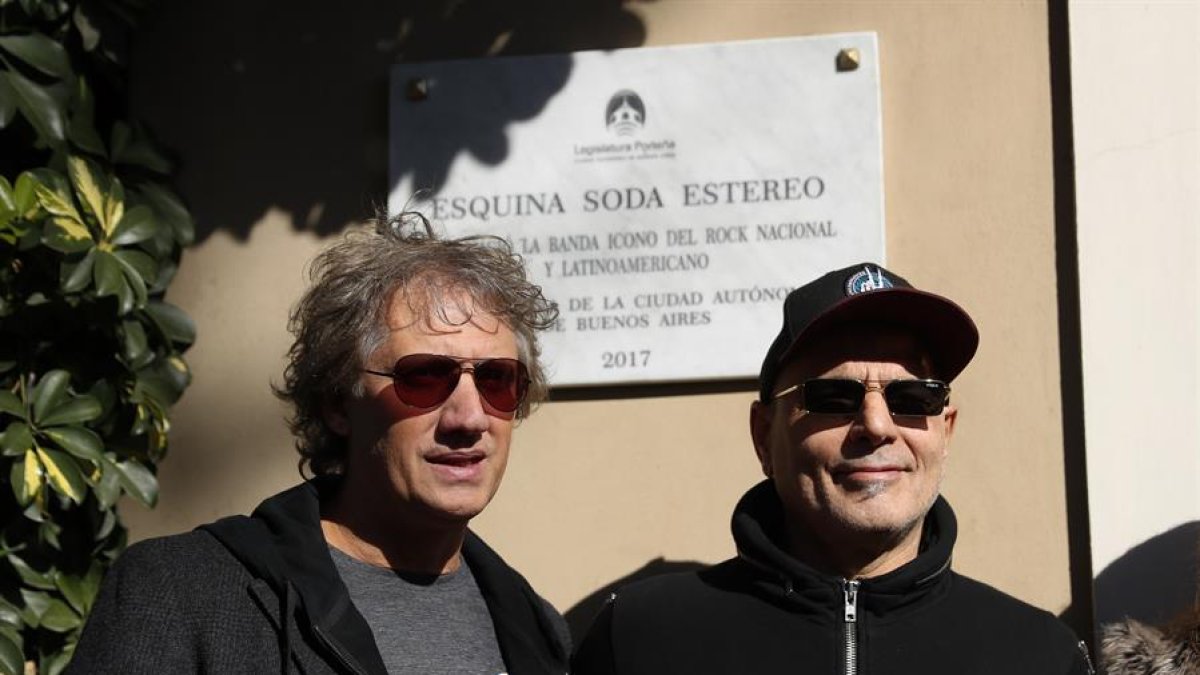 Los dos integrantes fundadores de la banda, 'Zeta' y 'Charly Alberti', delante de una placa en la casa donde se formó la banda en Buenos Aires.