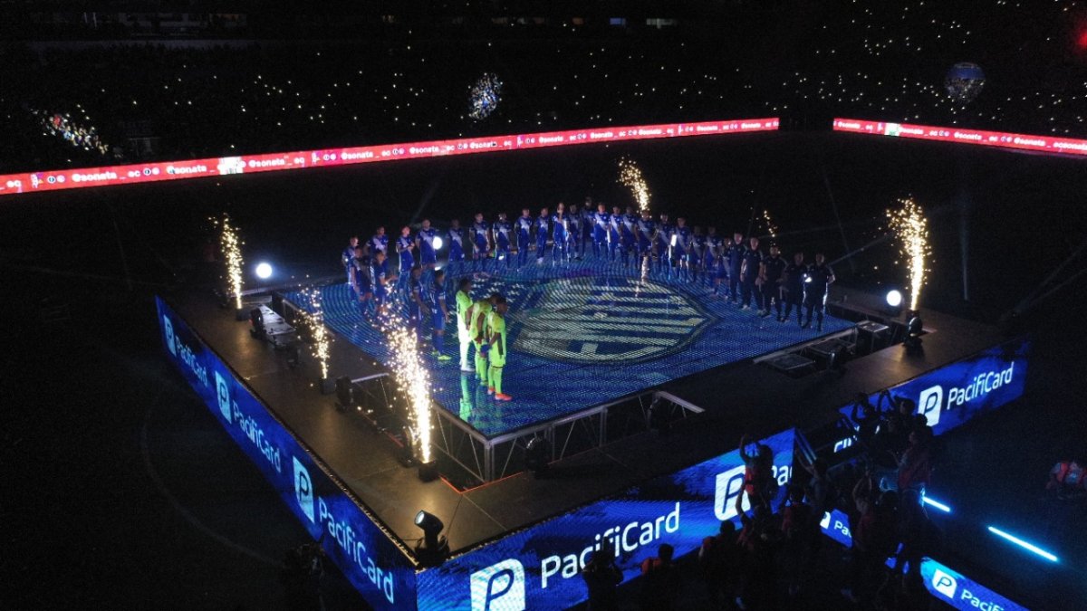 Los jugadores y cuerpo técnico se ubicaron en una tarima luminosa que se encontraba en medio del gramado del estadio.