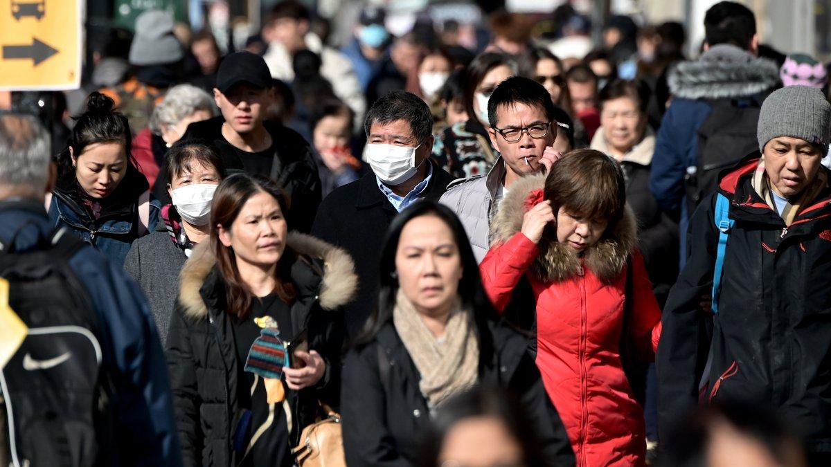 La gente usa máscaras quirúrgicas por temor al coronavirus en Flushing, un vecindario en el distrito de Queens de la ciudad de Nueva York .