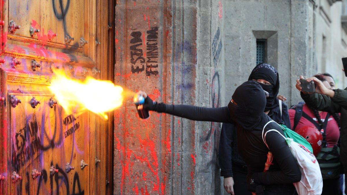 Un centenar de mujeres pintaron la fachada y una de las puertas del Palacio Nacional mexicano para protestar contra los feminicidios en México.