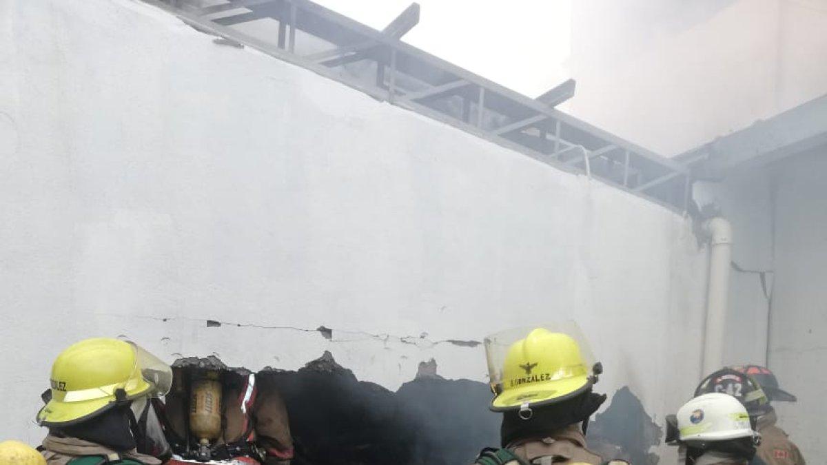 Bomberos ingresan al edificio para calmar las llamas.