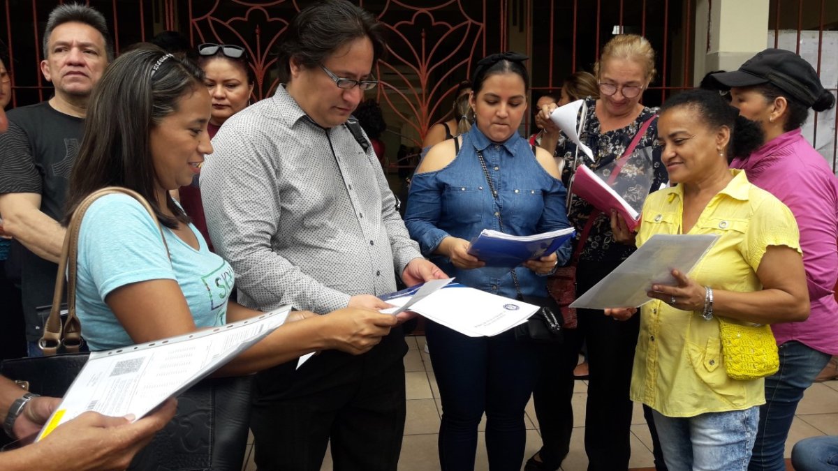 Padres de familias  muestran las hojas con el número de aciertos que tuvieron sus hijos en la primera prueba.