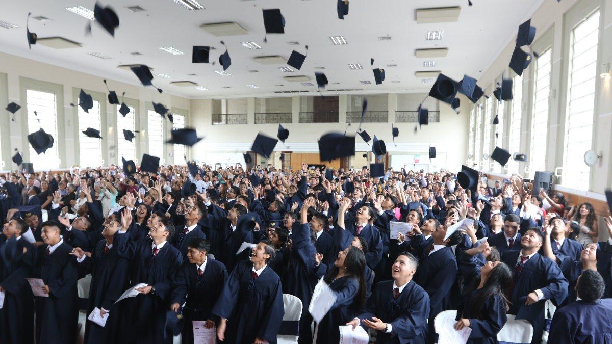 Los nuevos bachilleres lanzan sus birretes al aire, con símbolo de emoción por la culminación de una etapa estudiantil.