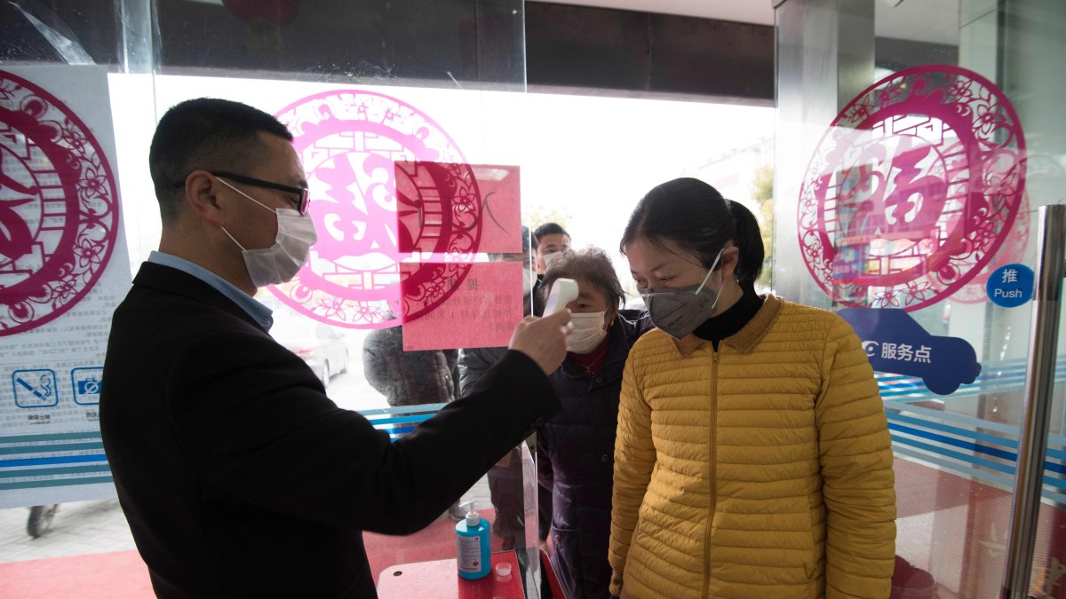 Un cliente a quien le tomaron la temperatura en la entrada de un banco en Nantong, en la provincia oriental china de Jiangsu.