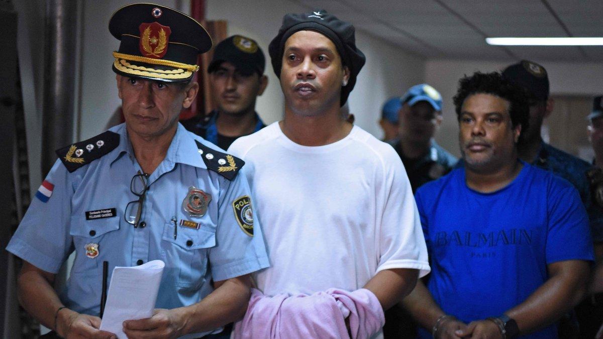 Ronaldinho (C) y su hermano, Roberto Assis (d) fueron detenidos el viernes y el sábado se les dictó orden de prisión. Permanecen en el edificio de una función judicial.
