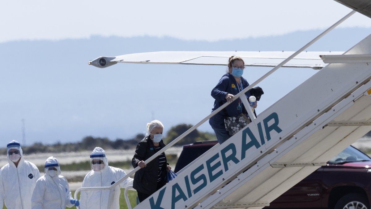 Los pasajeros del crucero Grand Princess reciben ayuda para abordar un avión en el Aeropuerto Internacional de Oakland, California. Al menos 21 personas a bordo del barco dieron positivo por coronavirus.