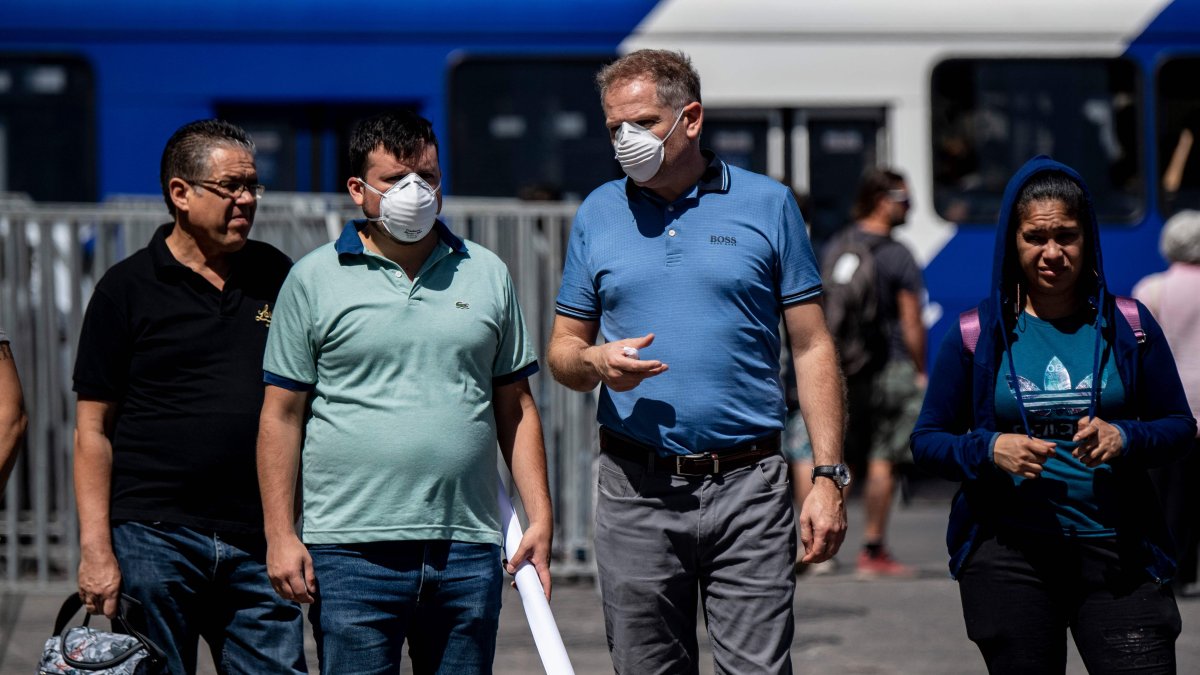Transeúntes chilenos caminan por las calles de Santiago donde se extreman cuidados para el contagio.