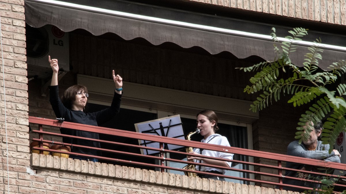 Una mujer toca el saxofón desde su balcón debido al nuevo coronavirus en Valencia, España)