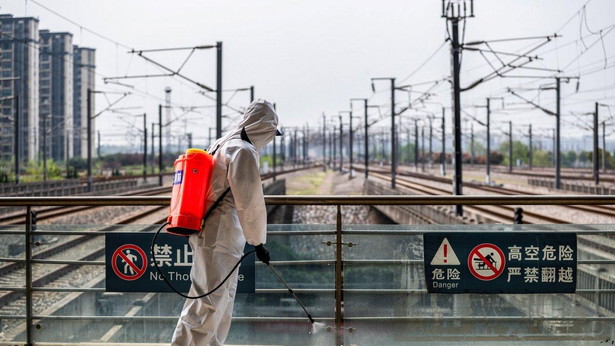WUHAN. Un trabajador sanitario recorre un área urbana desinfectando espacios públicos en esta ciudad china.