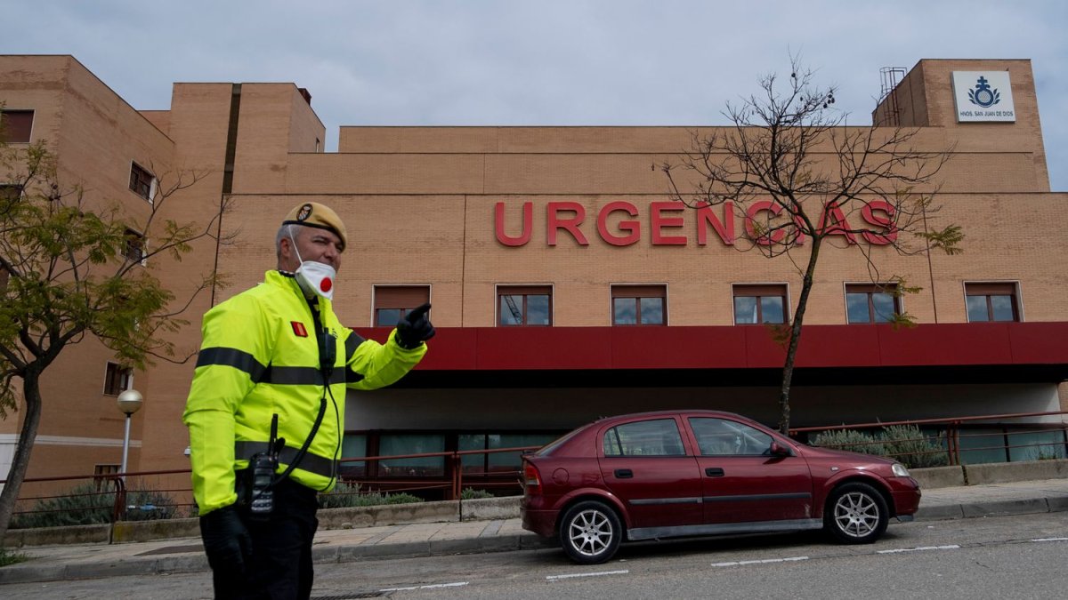 Un miembro de la Unidad Militar de Emergencias ante la puerta del hospital San Juan de Dios, España.