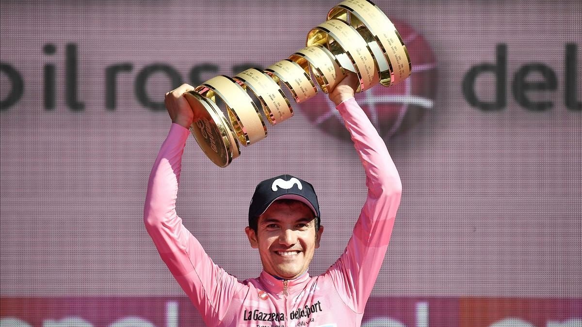 Richard Carapaz sostiene el trofeo del Giro de Italia logrado el año anterior.