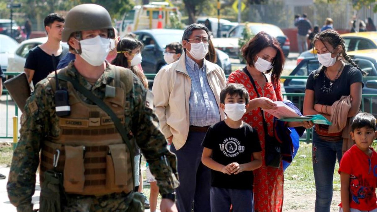 En el marco del coronavirus, un grupo de personas hacen fila para vacunarse contra la influenza en el Estadio Bicentenario de la Florida este sábado, en Santiago de Chile. EFE/Sebastián Silva