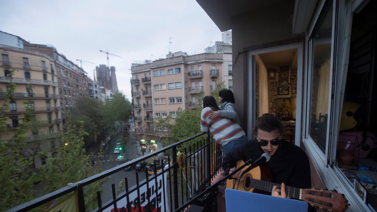 BARCELONA. Un músico ofrece a sus vecinos un concierto desde su balcón en el decimosexto día de aislamiento.