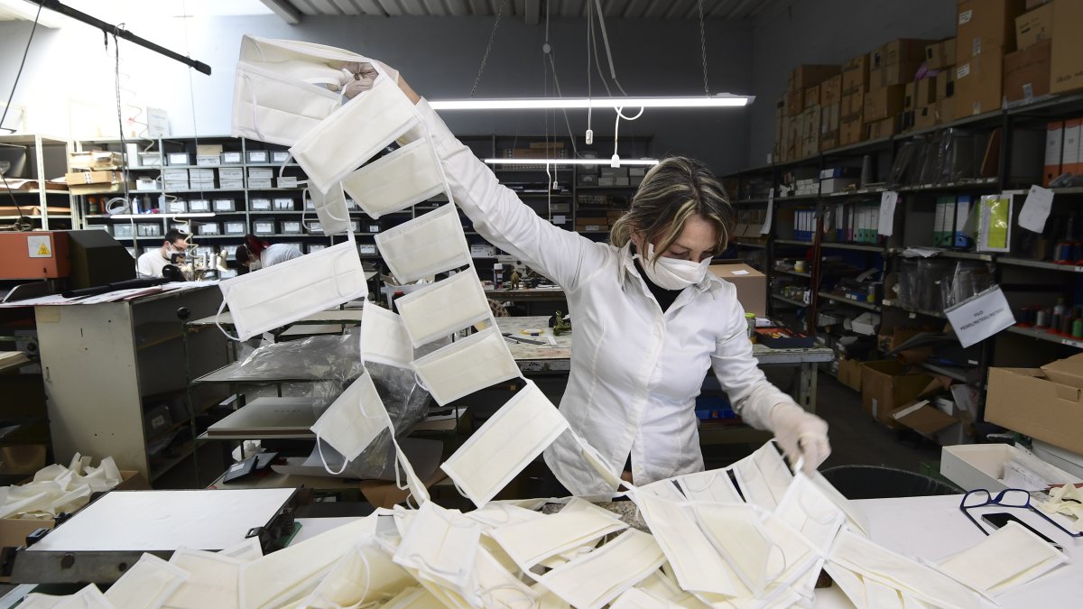 Una empleada controla las máscaras quirúrgicas en un taller de cuero convertido en una fábrica de mascarillas, cerca de Vigevano, Lombardía