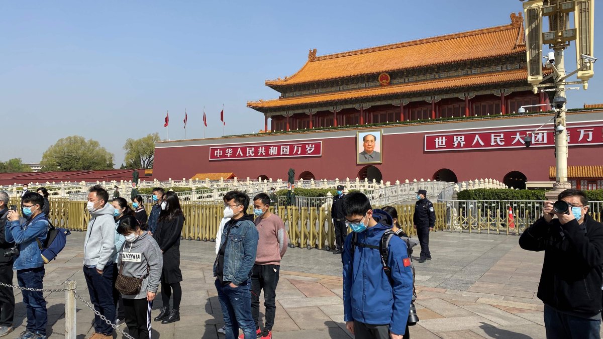 La gente se inclina frente a la Puerta de Tiananmen en Beijing durante un memorial nacional de tres minutos para conmemorar a las personas que murieron en el brote de coronavirus COVID-19,