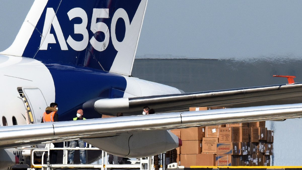 Trabajadores descargan del avión Airbus A350-1.000 máscaras faciales procedentes de China.