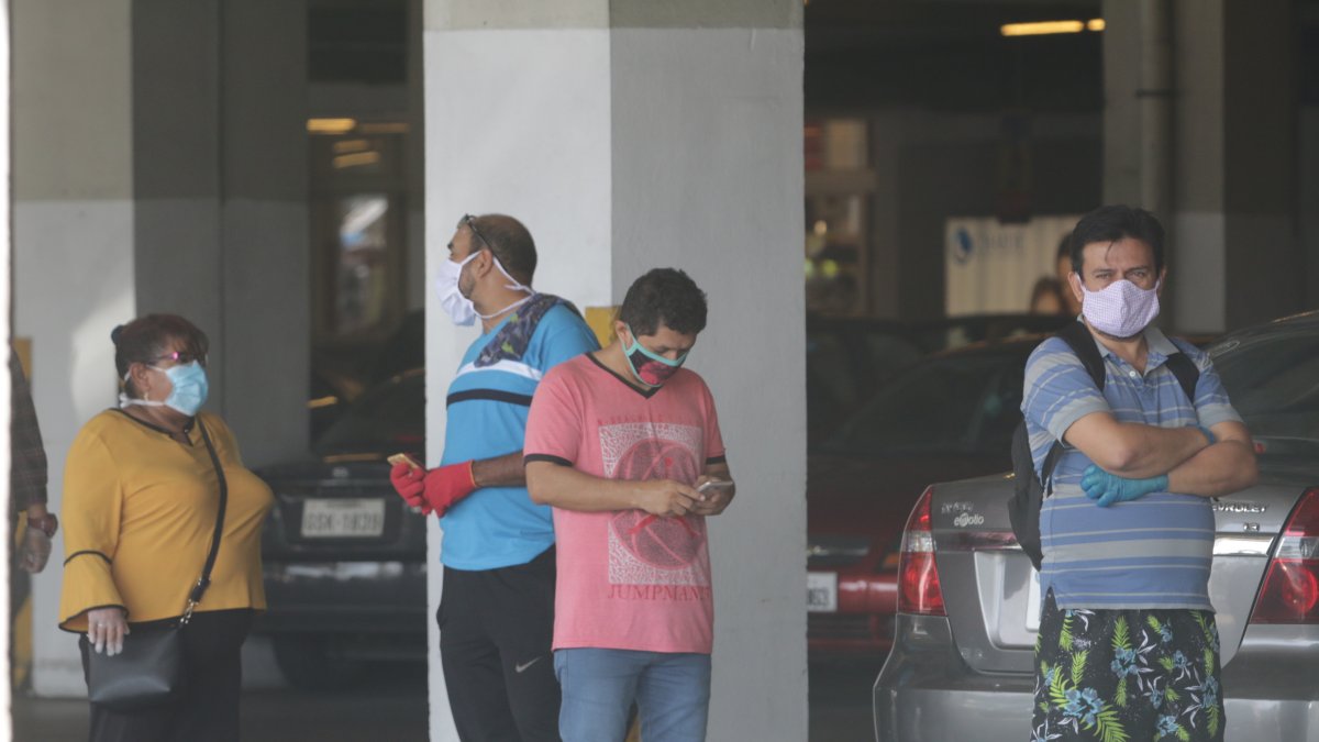 Personas toman sus precauciones al salir de sus casas para comprar víveres.