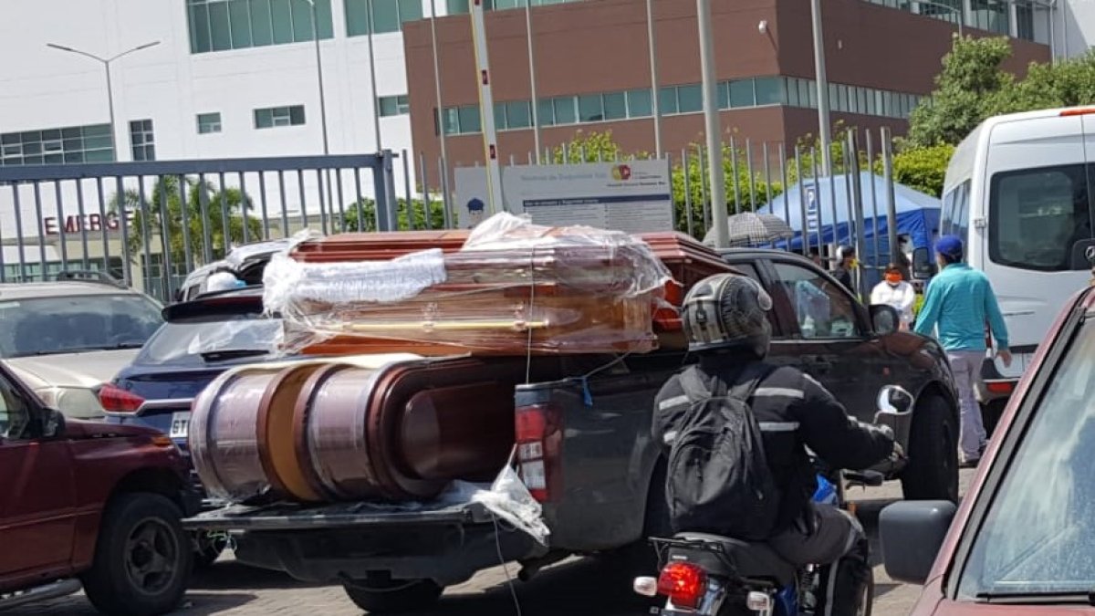 Camionetas llegan cargadas de ataúdes a los exteriores del hospital.