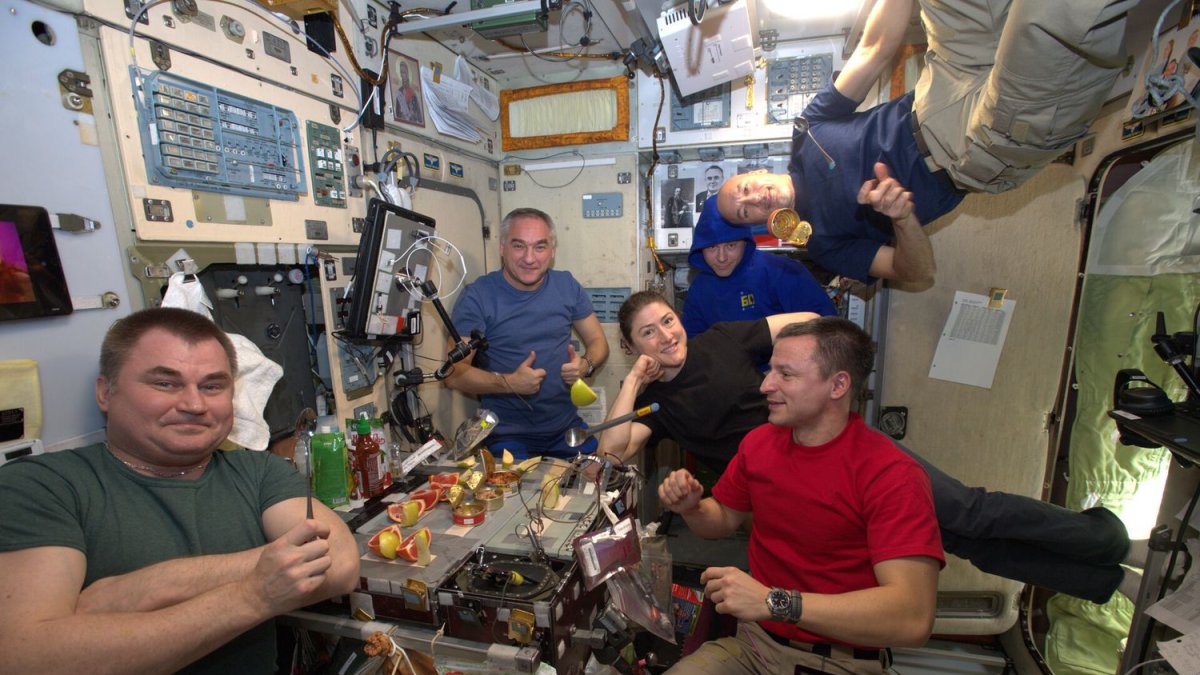 Estación Espacial Internacional. Astronautas celebrando una comida especial.