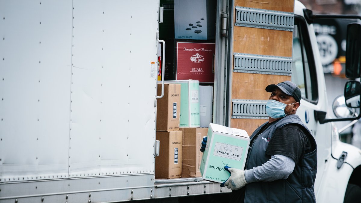 Un repartidor entrega vino a una licorería en Brooklyn, Nueva York. Se trata de un latino que, como muchos, no puede dejar de trabajar en la pandemia