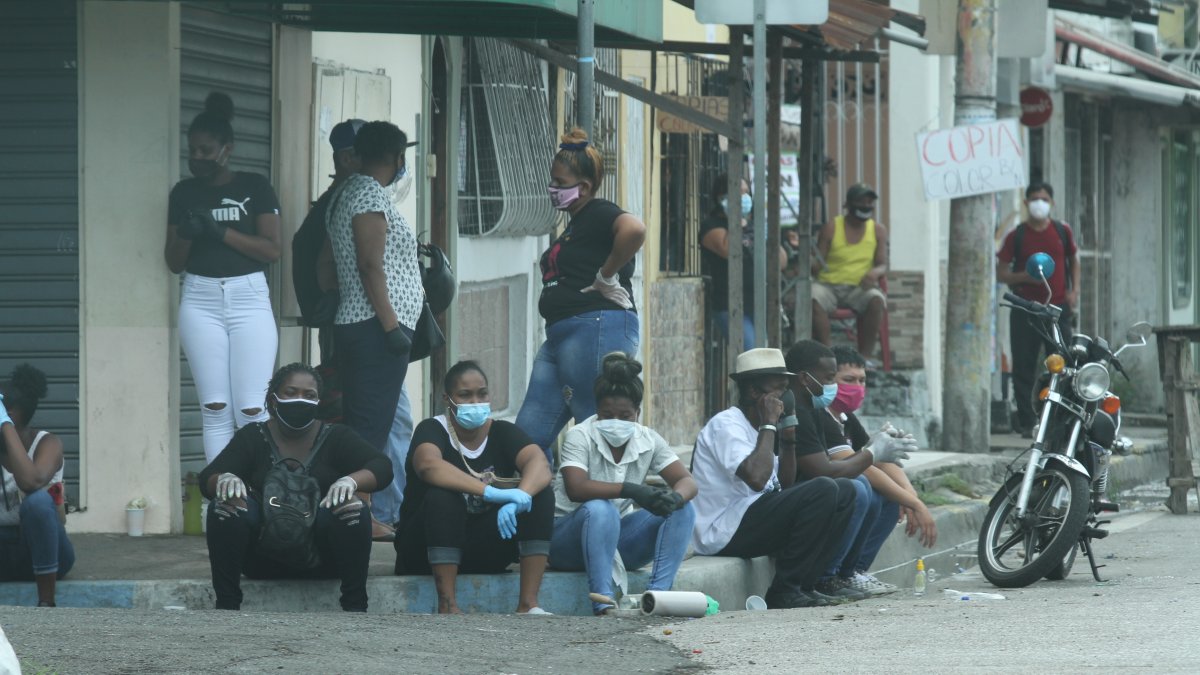 Ciudadanos en Guayaquil toman sus precauciones al usar mascarilla al exterior de un camposanto de la ciudad.