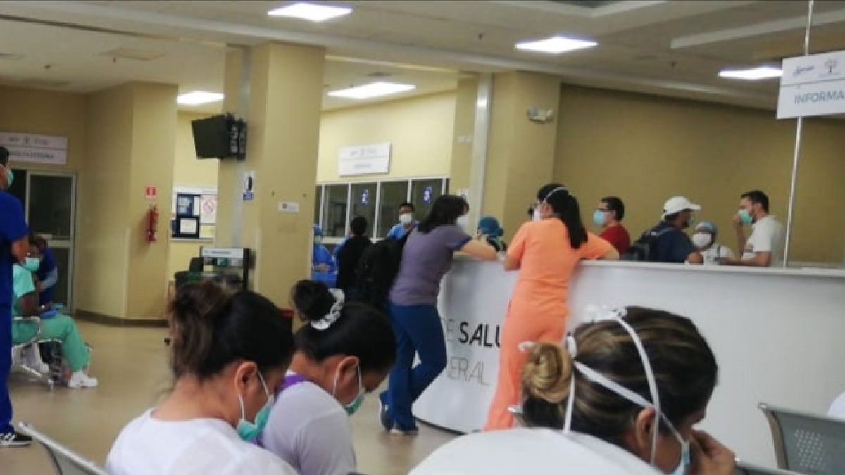 Un grupo de enfermeras espera en la entrada del Hospital del Guasmo para que les den trajes y mascarillas apropiadas para trabajar en el turno del martes 14 de abril de 2020.