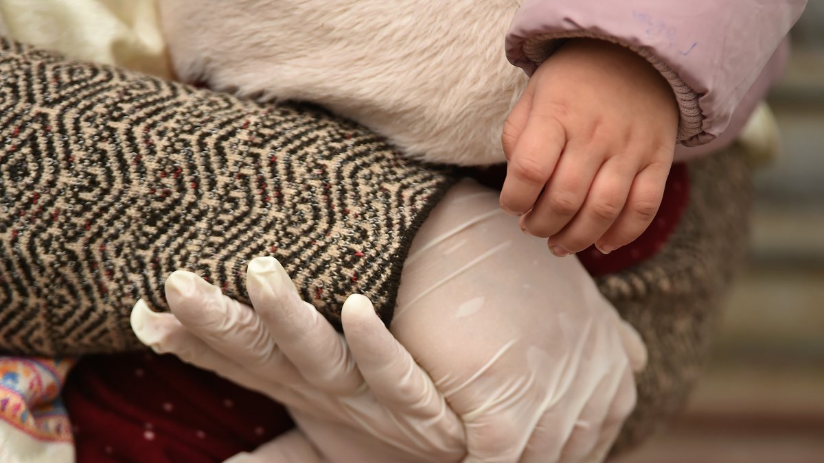 Una madre sostiene a su hijo después de completar 14 días de cuarentena en un hotel de India, durante el cierre  impuesto por el gobierno como medida preventiva contra el COVID-19