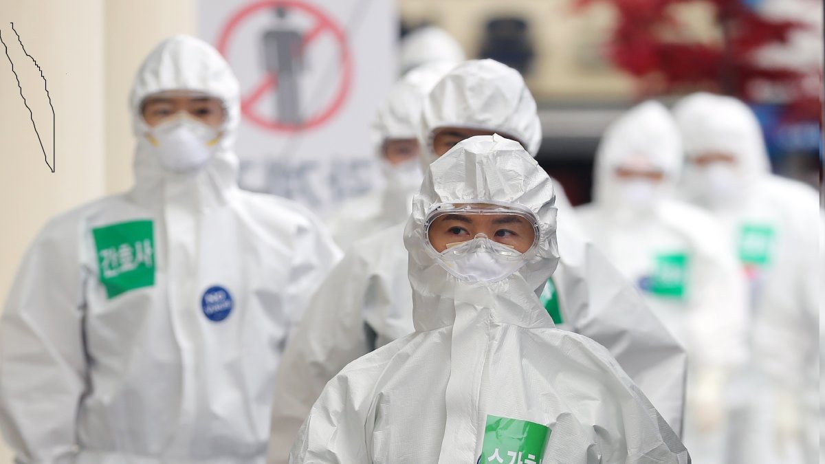 Los trabajadores médicos con equipo de protección caminan hacia las salas, para pacientes con COVID-19, antes de su turno de trabajo en el Hospital Dongsan en Daegu, Corea del Sur