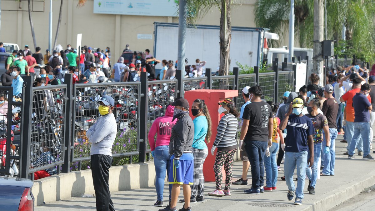 Los ciudadanos siguen aglutinándose en los exteriores de supermercados para abastecerse de víveres. Usan mascarillas, pero no respetan la distancia social.
