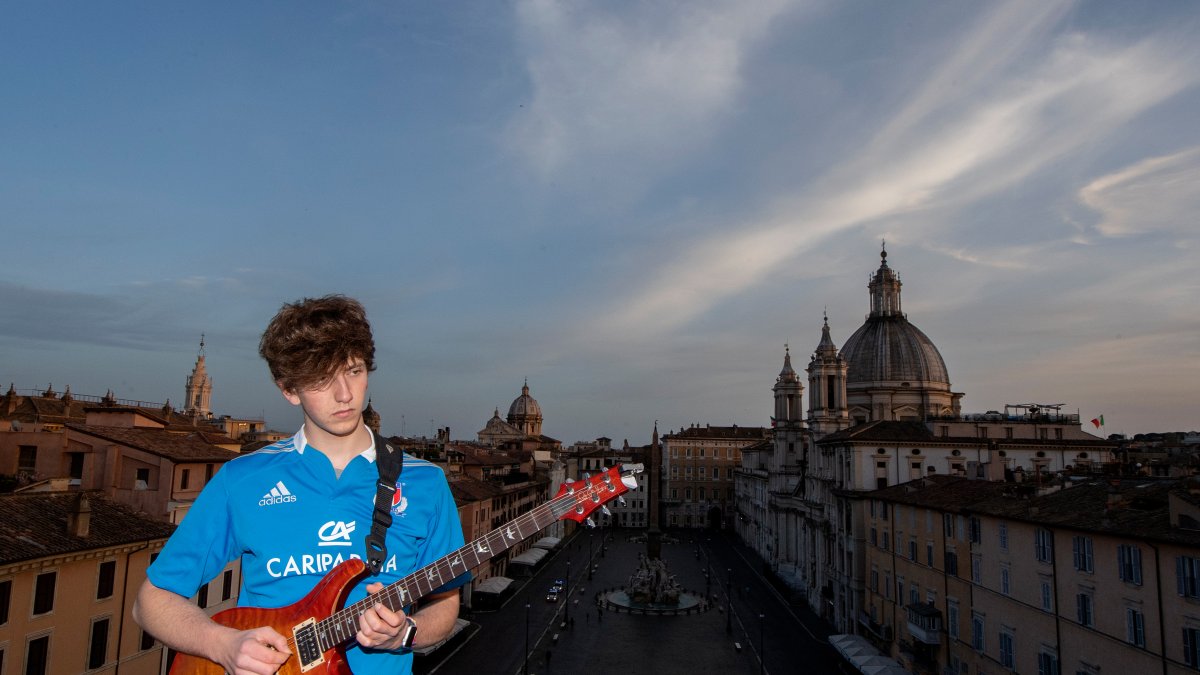 Jacopo Mastrangelo toca la guitarra desde su terraza con vistas a la Piazza Navona en Roma, durante el encierro en Italia para frenar la propagación de la pandemia COVID-19