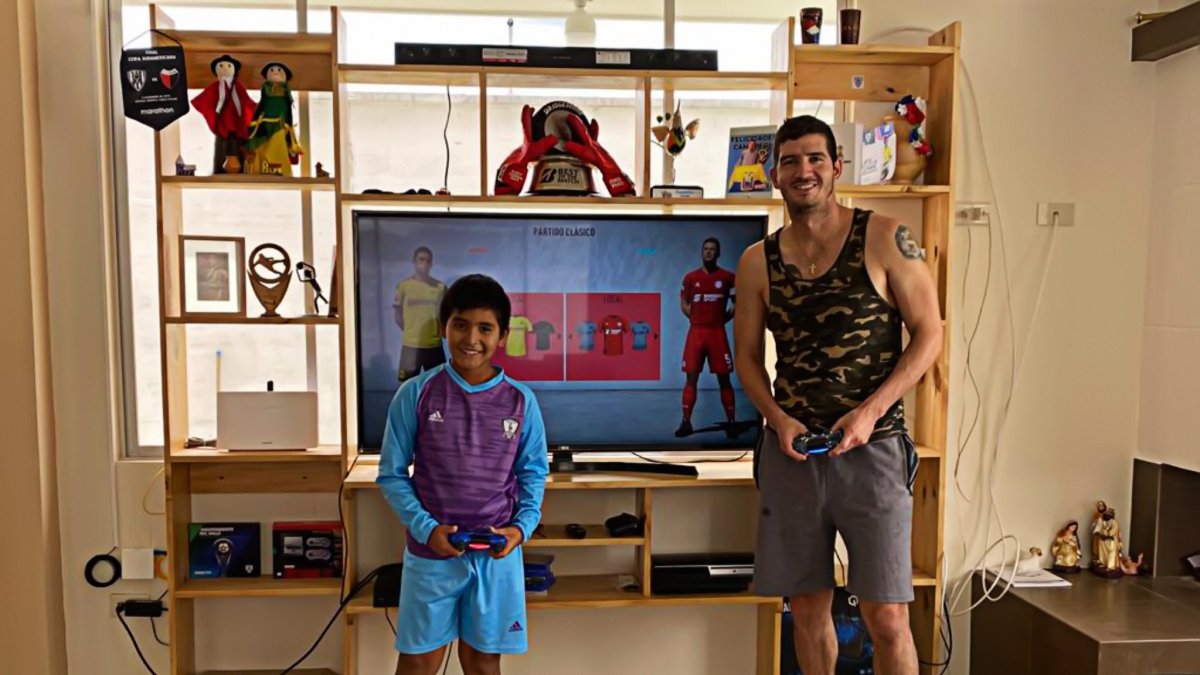 Jorge Pinos juega Play Station con su hijo pata entretenerse en la cuarentena.