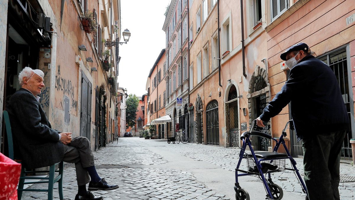 Ancianos conversan en el barrio de Trastevere, en Roma. La zona norte del Italia, la más afectada por el coronavirus, está presionando al Gobierno para acelerar la reapertura del país.