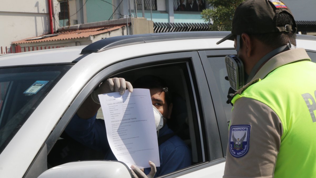 Un conductor muestra su salvoconducto a un oficial de la Policía Nacional.
