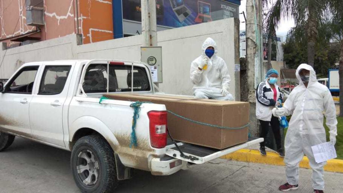 Un par de ayudantes de Édison Zúñiga suele colocar los féretros en su camioneta.