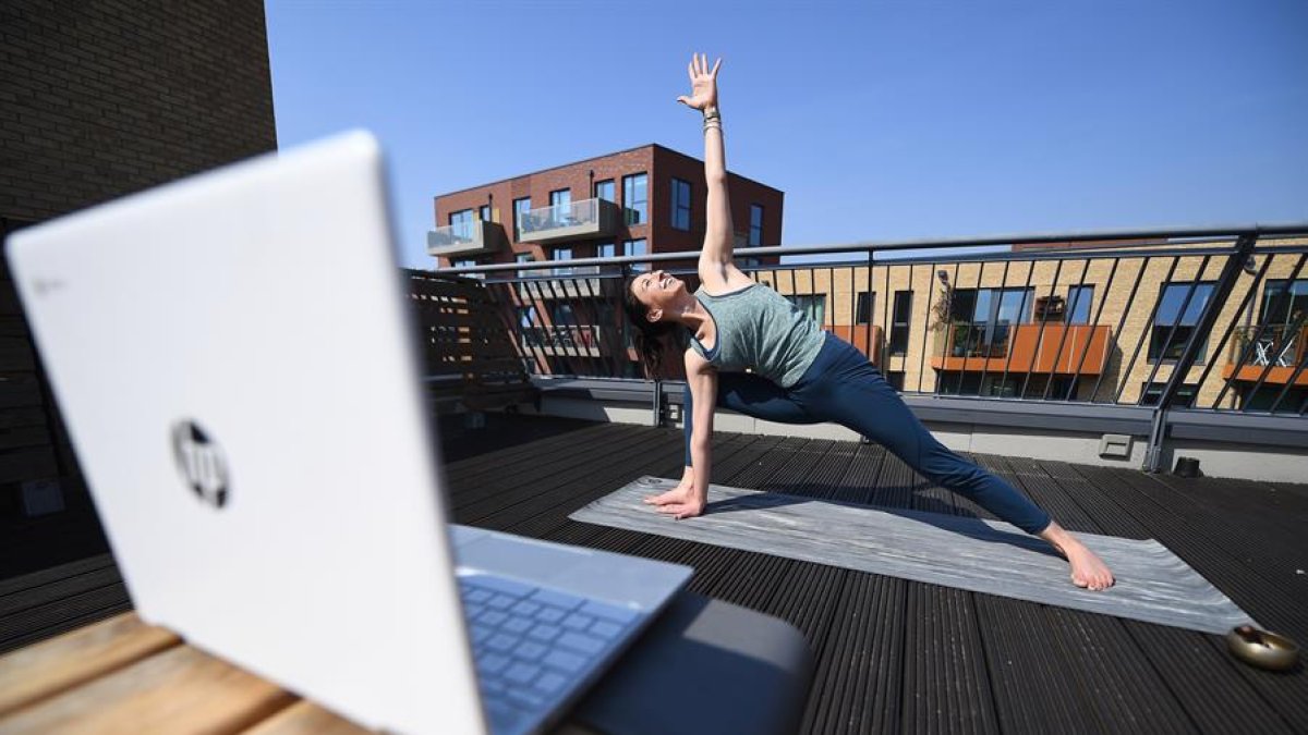 La italiana Claudia Spurio da clases de yoga desde su departamento en Londres, a través de la plataforma Zoom.