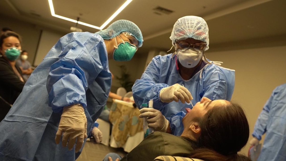 Expertos realizan el examen de COVID-19 a una persona.