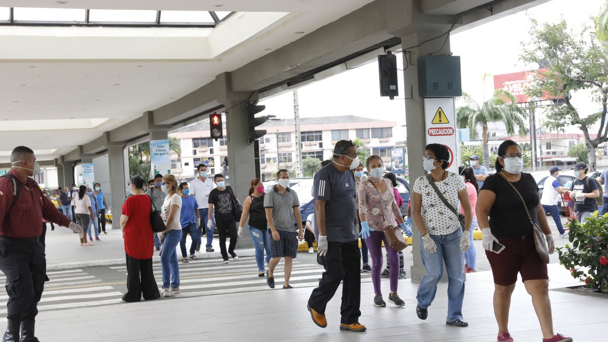 Un grupo de personas hacen fila para ingresar a bancos y a un supermercado.