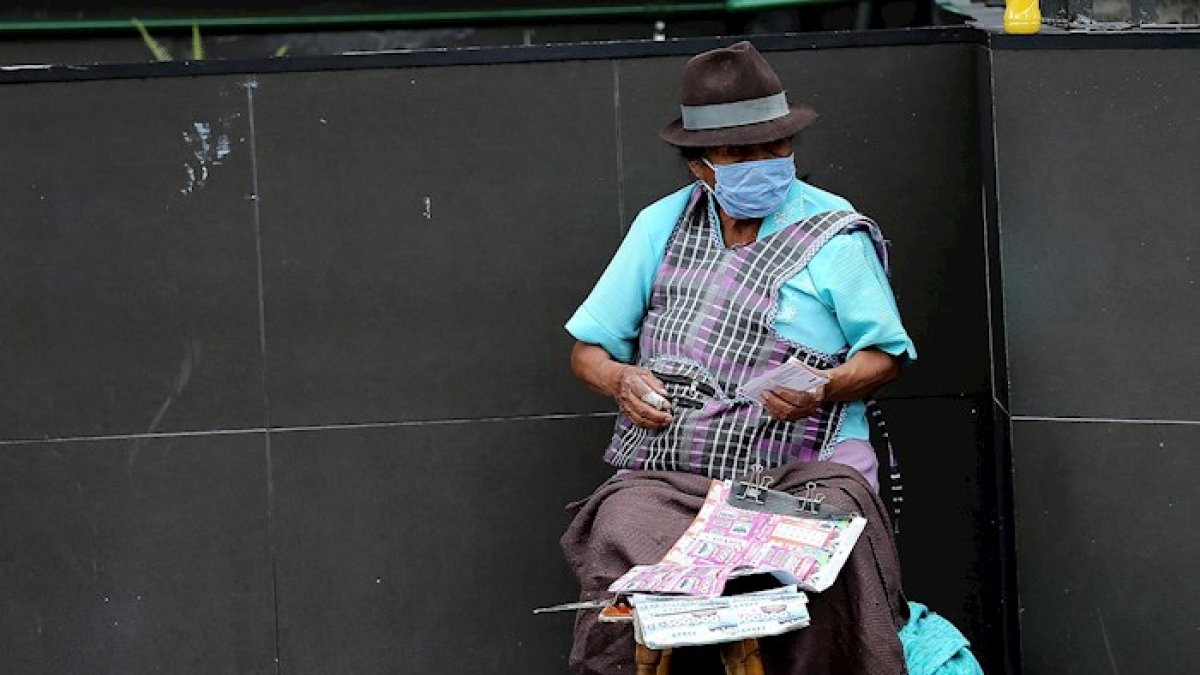 Una mujer con tapabocas vende lotería en las calles de Quito (Ecuador).