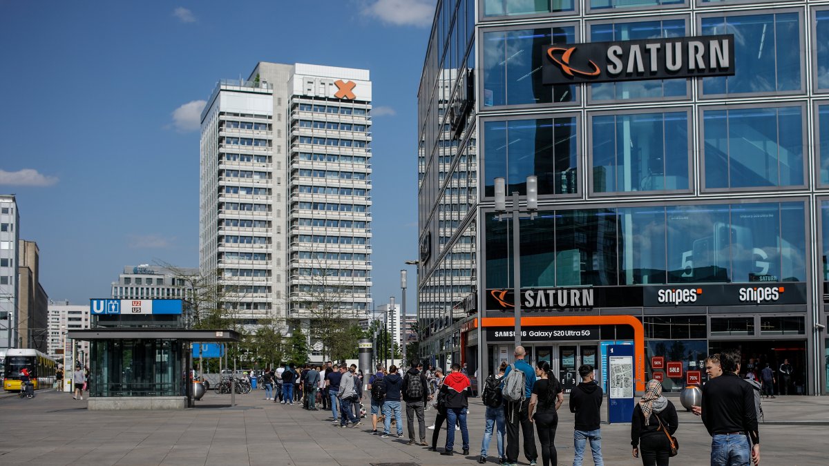 BERLÍN. Una larga fila forman los ciudadanos alemanes, manteniendo el distanciamiento social, que solicita el gobierno, a la entrada de una tienda de equipos electrónicos.
